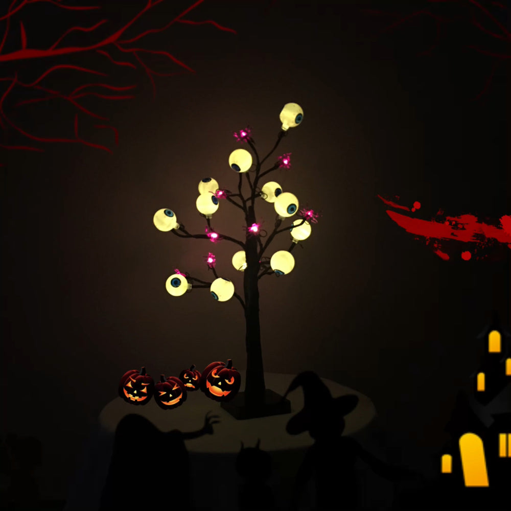 Schaurige Augenbaum-Lampe als Halloween-Deko zwischen kleinen Kürbissen im Dunkeln