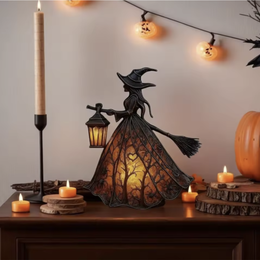 Dunkle Hexen-Lampe mit leuchtendem Astmuster-Kleid auf einer Holzkommode zwischen Kerzen und Kürbis-Lichterkette