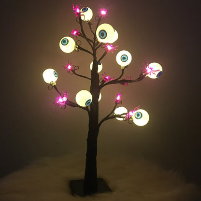 Nahaufnahme der Schaurigen Augenbaum-Lampe mit leuchtenden Augäpfeln an schwarzen Zweigen