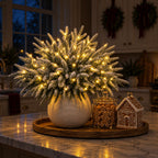 Leuchtende Tannenzweige Verschneit mit weißen Spitzen auf der Kücheninsel neben Lebkuchen