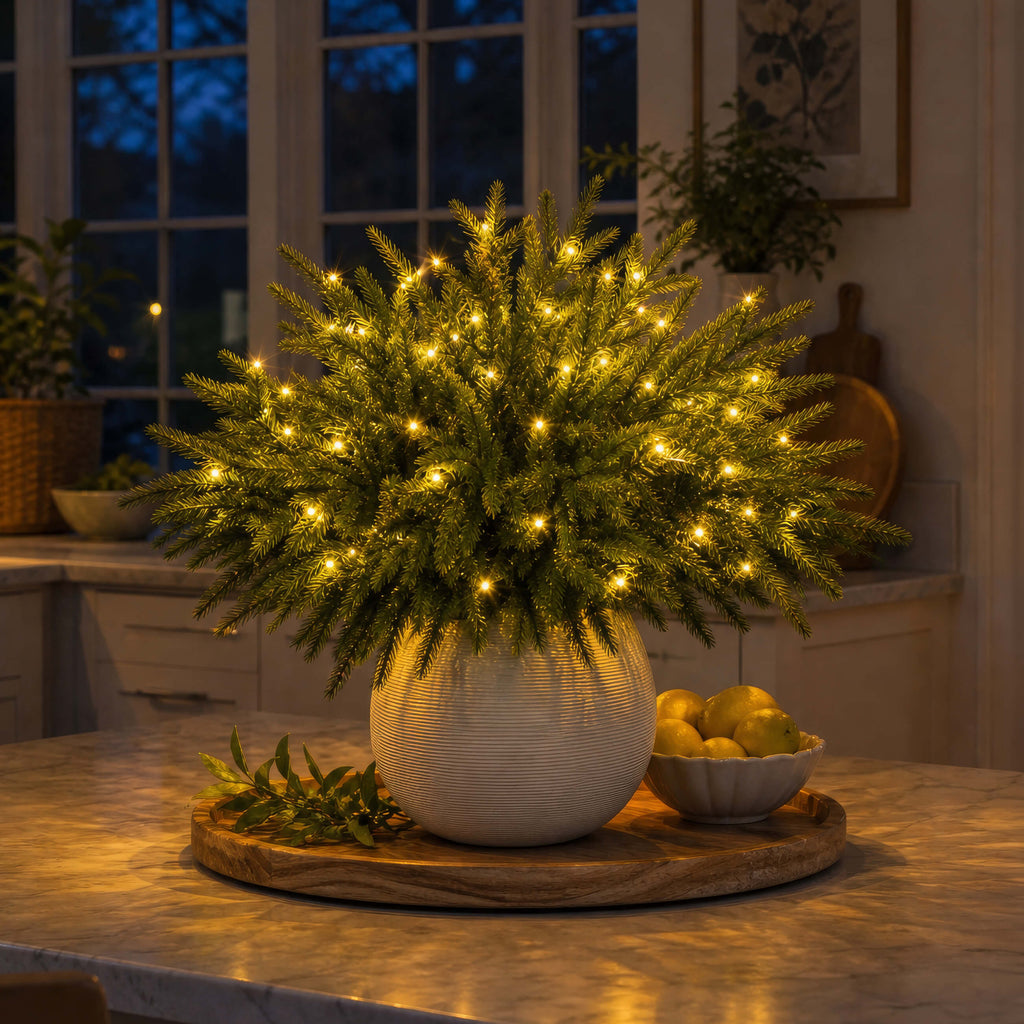 Leuchtende Tannenzweige Klassisch in heller Vase auf der Kücheninsel, warmgoldene Lichtpunkte am Abend