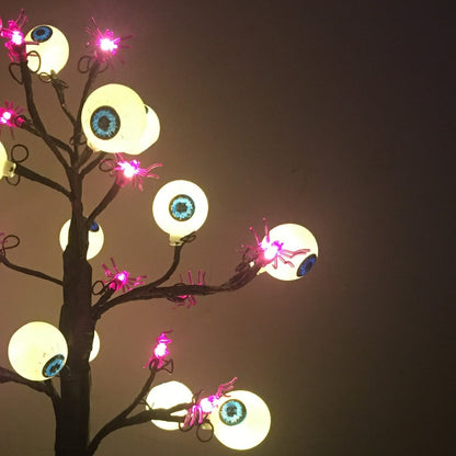 Detail der Schaurigen Augenbaum-Lampe: leuchtende Augen und kleine lila Spinnen an den Zweigen