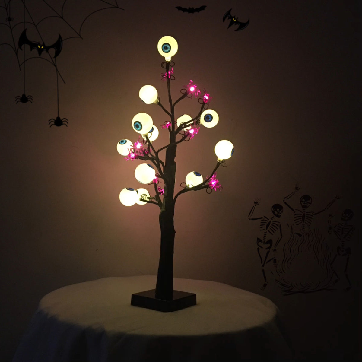 Schaurige Augenbaum-Lampe leuchtet im dunklen Raum mit warmen Augen und lila Spinnen